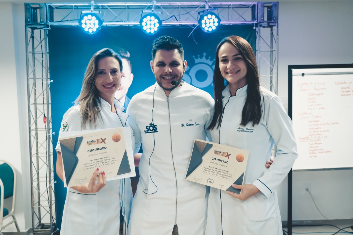 Sóstenes entregando certificados a alunas no palco da imersão
